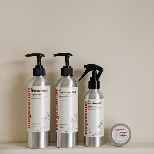 Set of 'the nourishing fluff' pet care natural products for dogs including shampoo, conditioner, spray and paw balm on a neutral shelf