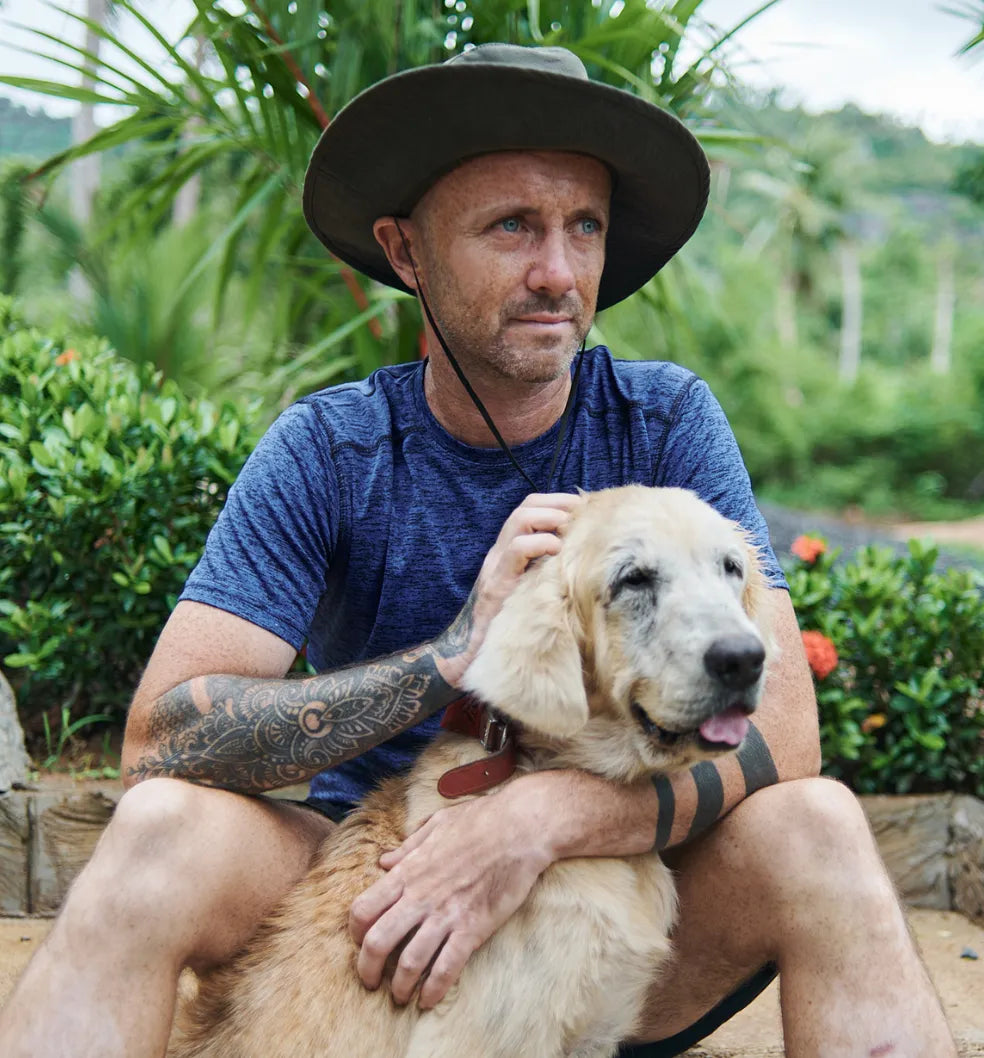 Niall Harbison from Happy Doggo sat with Tina, a golden retriever rescue street dog from Koh Samui