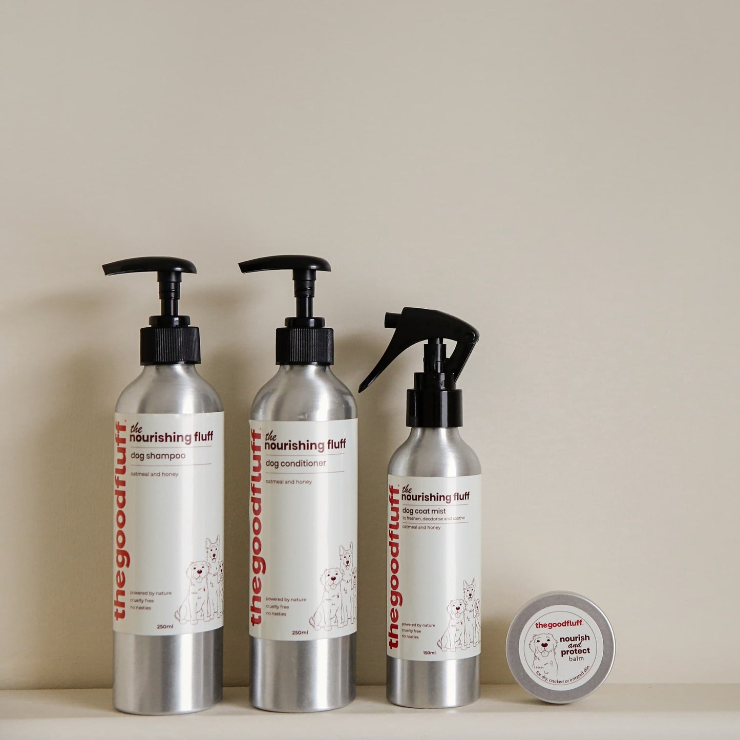 Bundle set of 'the nourishing fluff' pet care natural products for dogs including shampoo, conditioner, spray and paw balm on a neutral shelf